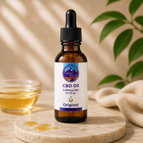 CBD oil dropper bottle with a label on a wooden surface with a glass of liquid and plant in the background.